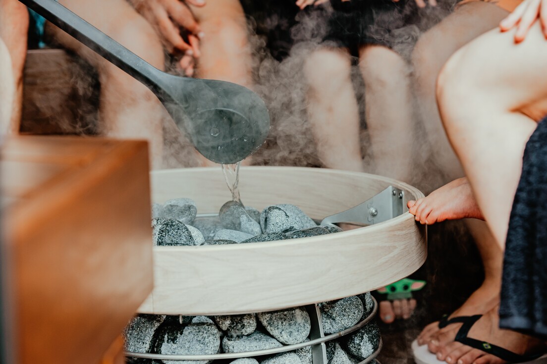 Menschen sitzen in der Sauna beim Aufguss